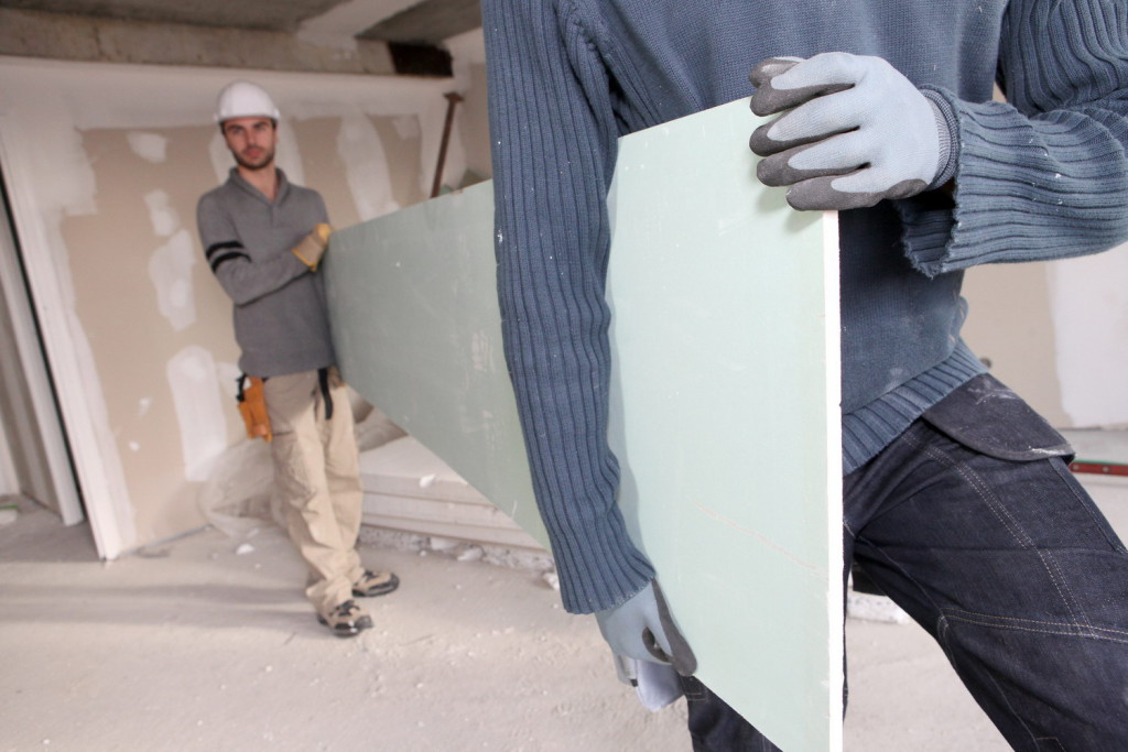Workers carrying plasterboard